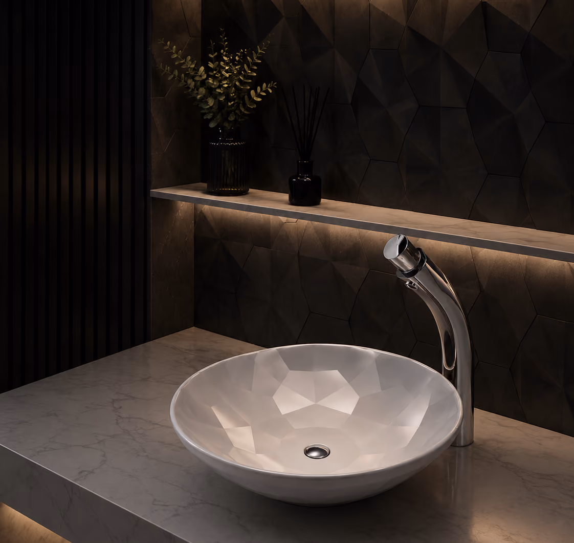 Pent faceted white basin with curved chrome mixer on a marble counter in a dark bathroom