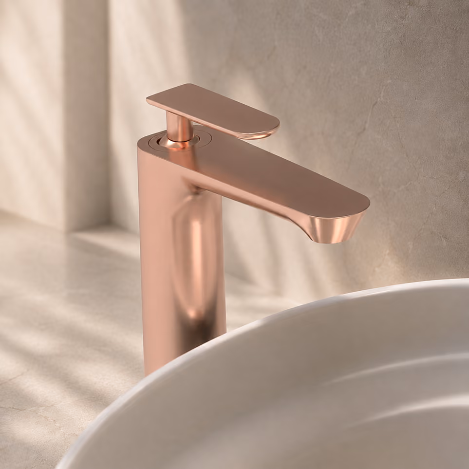 Rose gold single-lever basin mixer beside a white countertop basin on marble