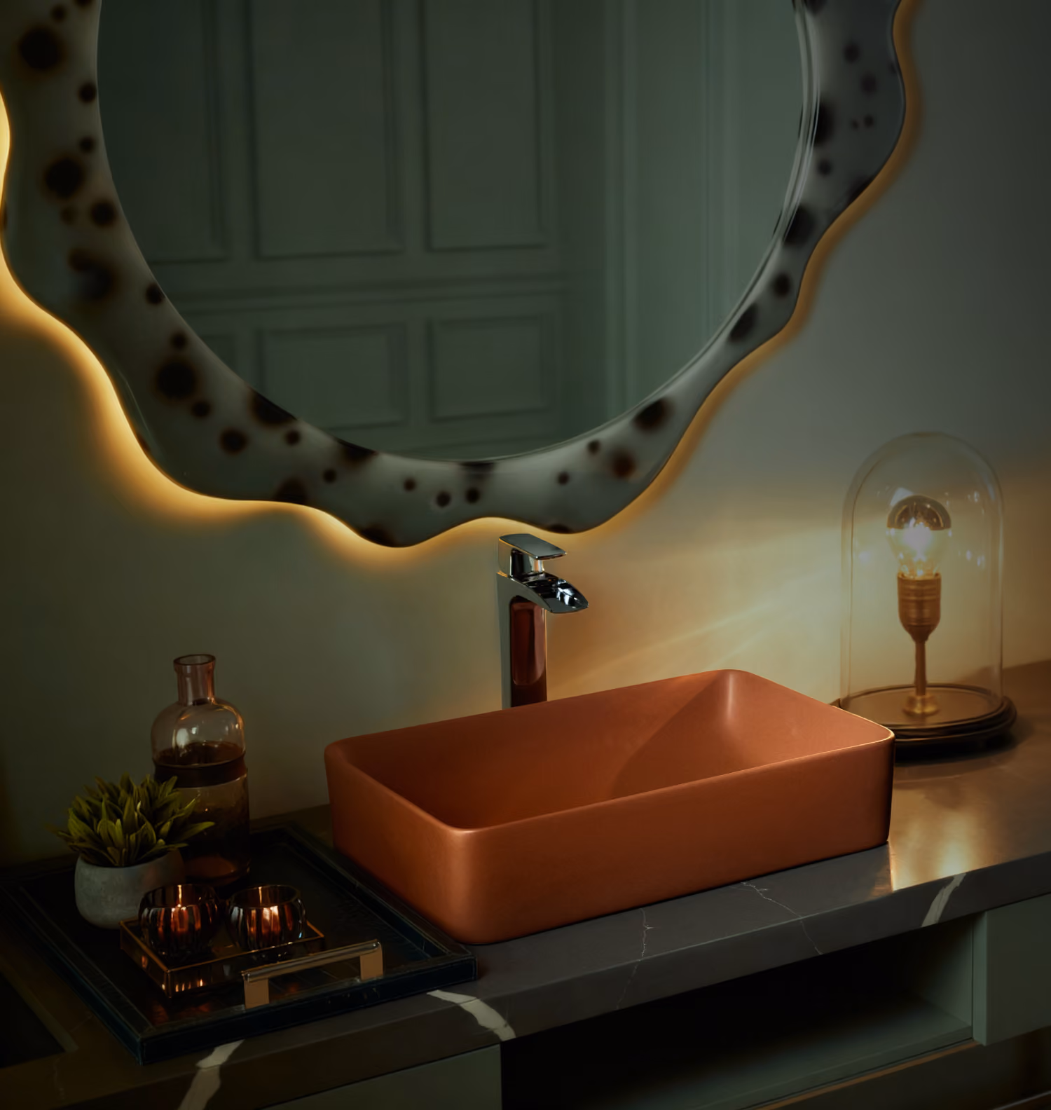 Terracotta rectangular vessel basin and chrome tap below a backlit wavy mirror in a dim bathroom