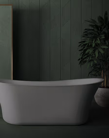 Freestanding slipper bathtub against a dark green patterned wall panel with a potted palm